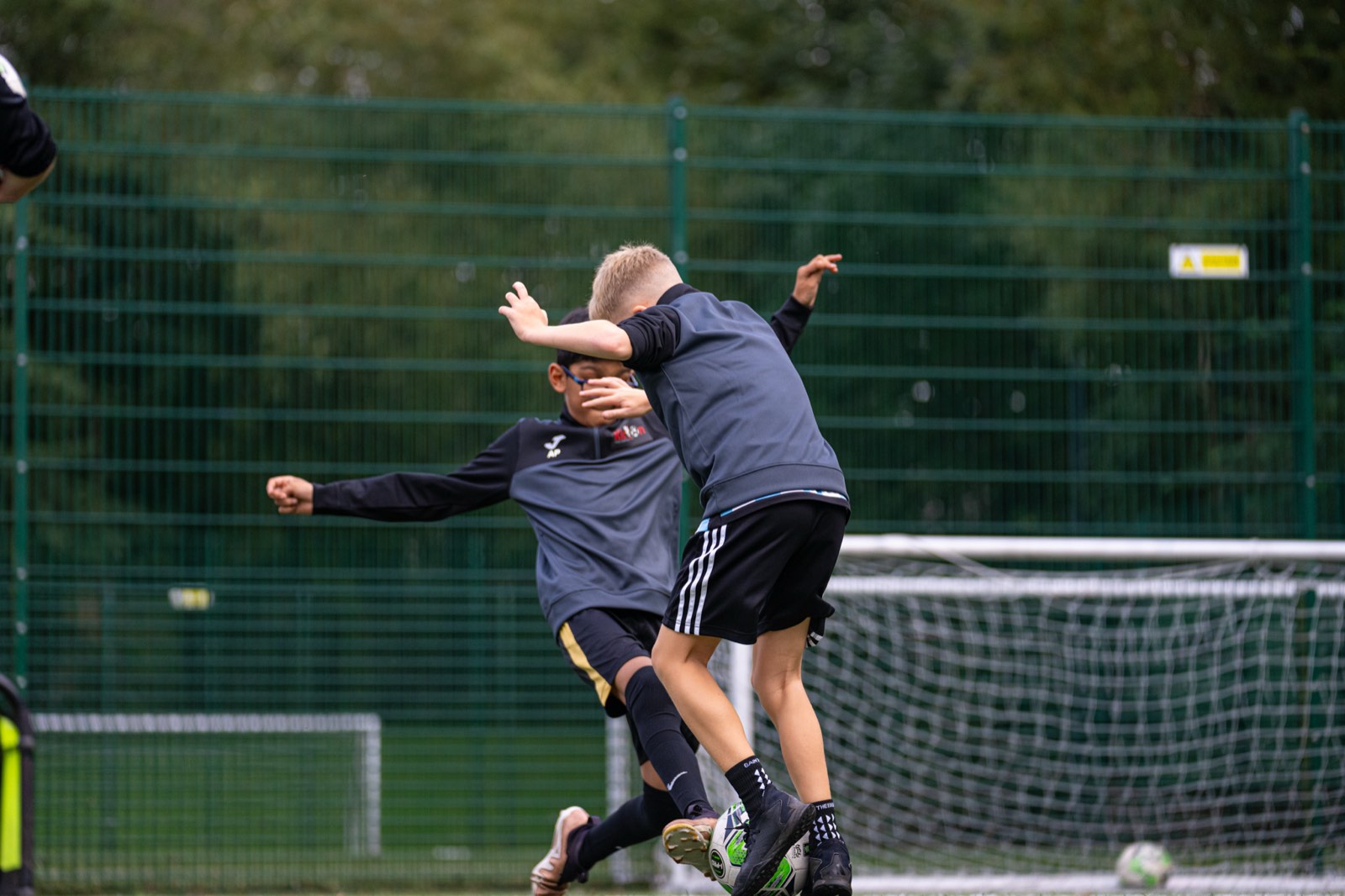 Two young players challenging for the ball in a Saturday small-sided game