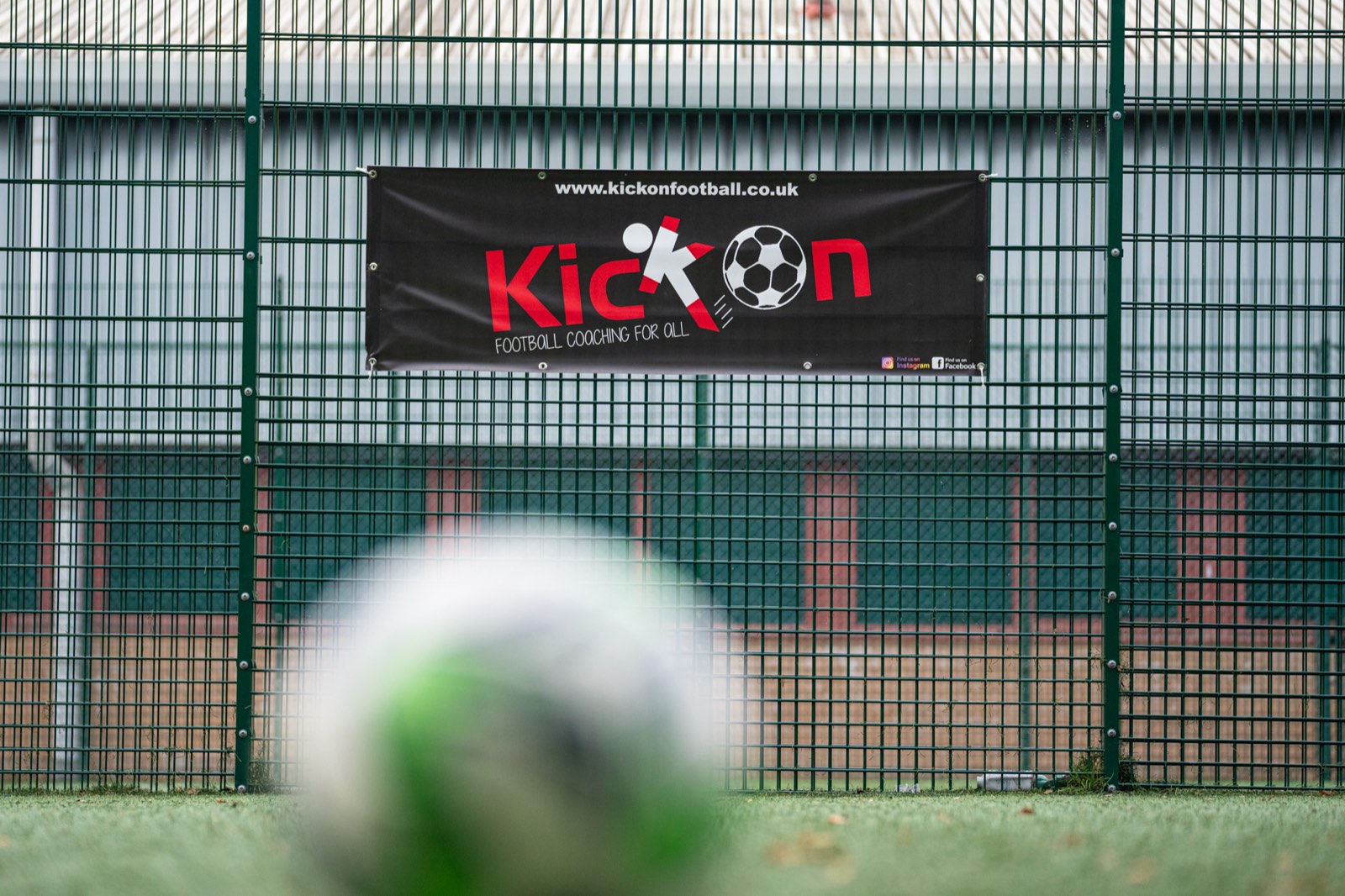 Kick On Football banner on the fence at a session venue