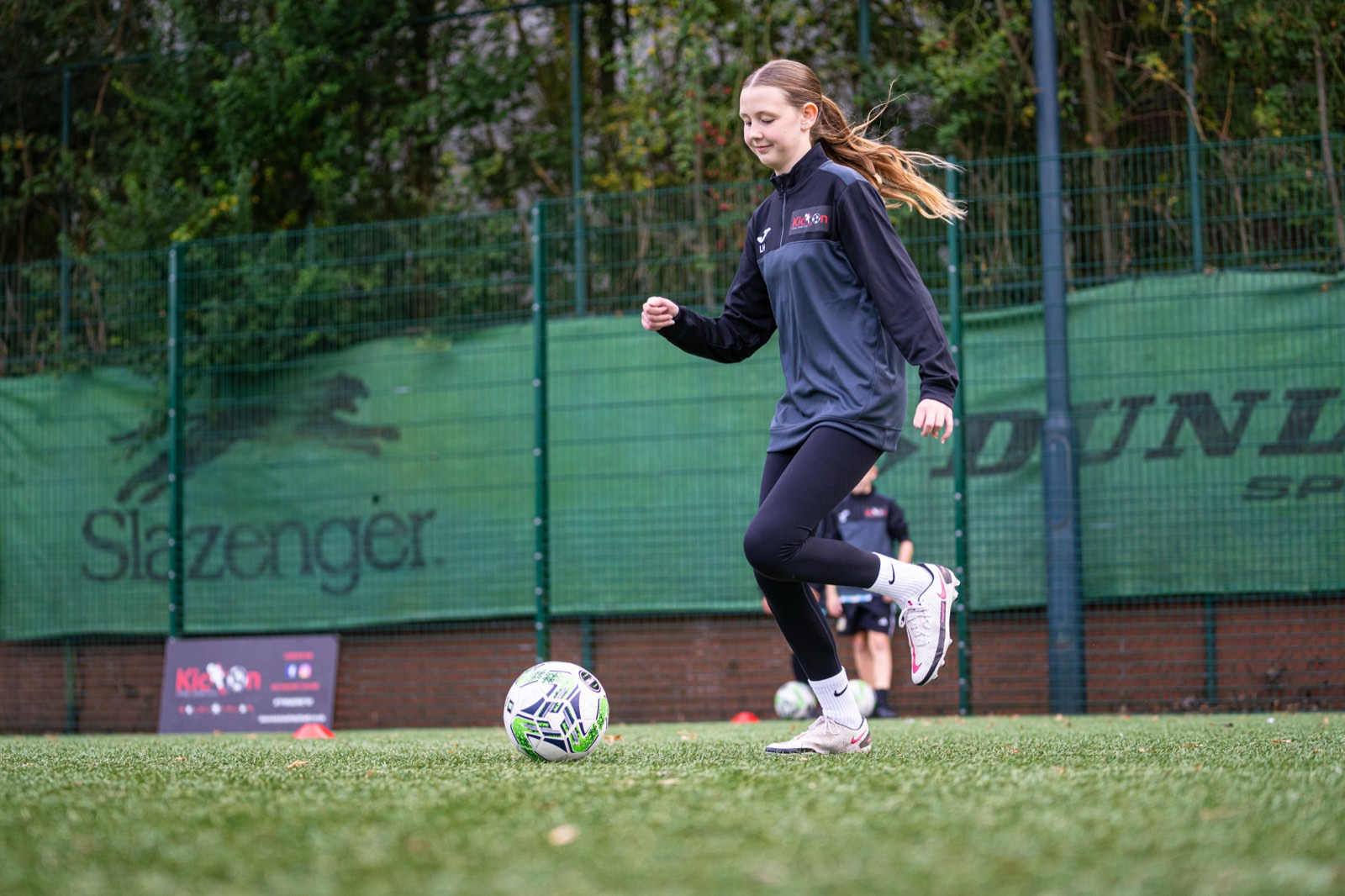 Girl running with the ball at a Kick On Girls session